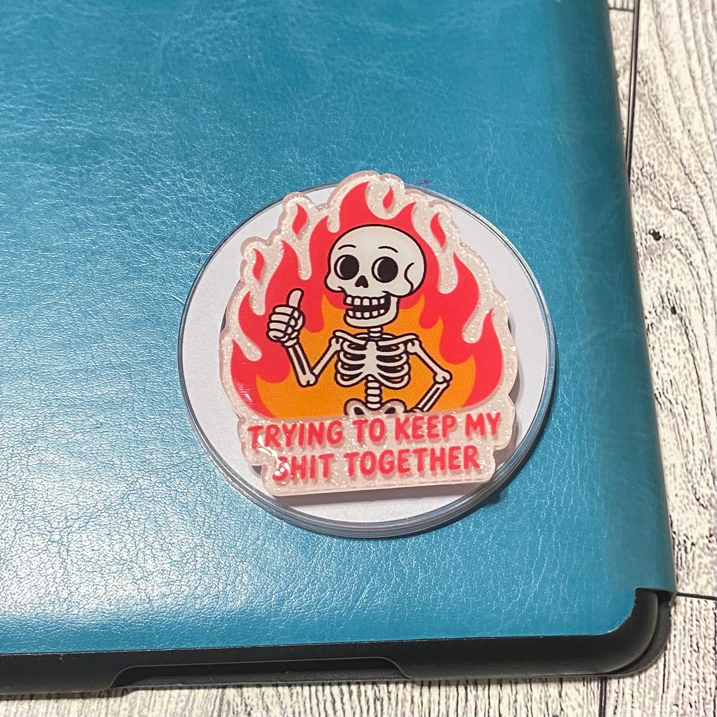 Sticker with a skeleton giving a thumbs up on a blue surface