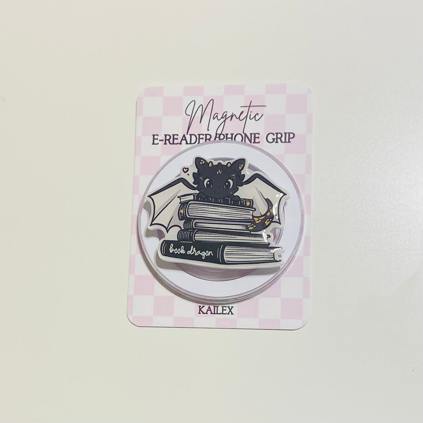 Magnetic e-reader phone grip with cat design on a checkered background