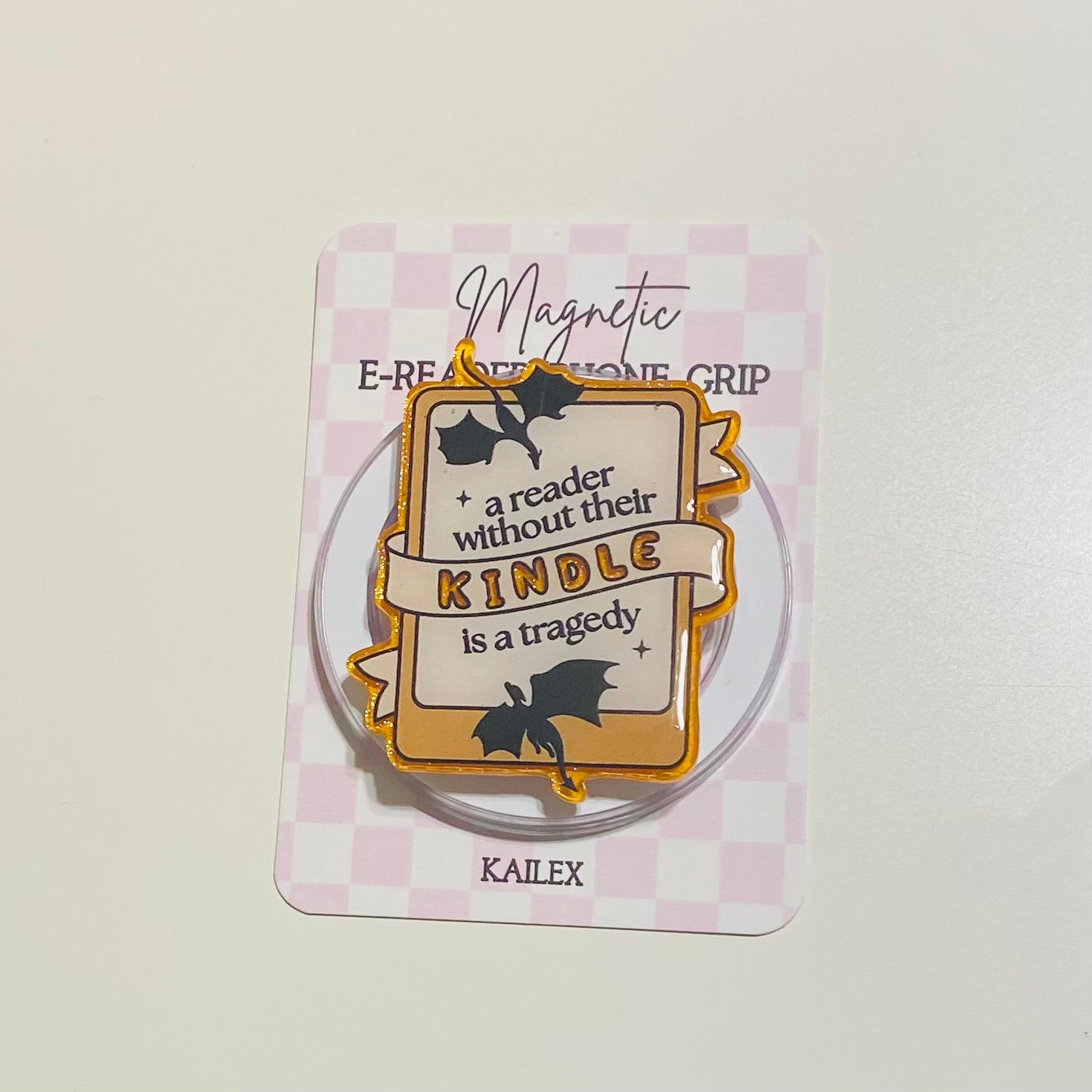 Magnetic e-reader phone grip with decorative design on a checkered background