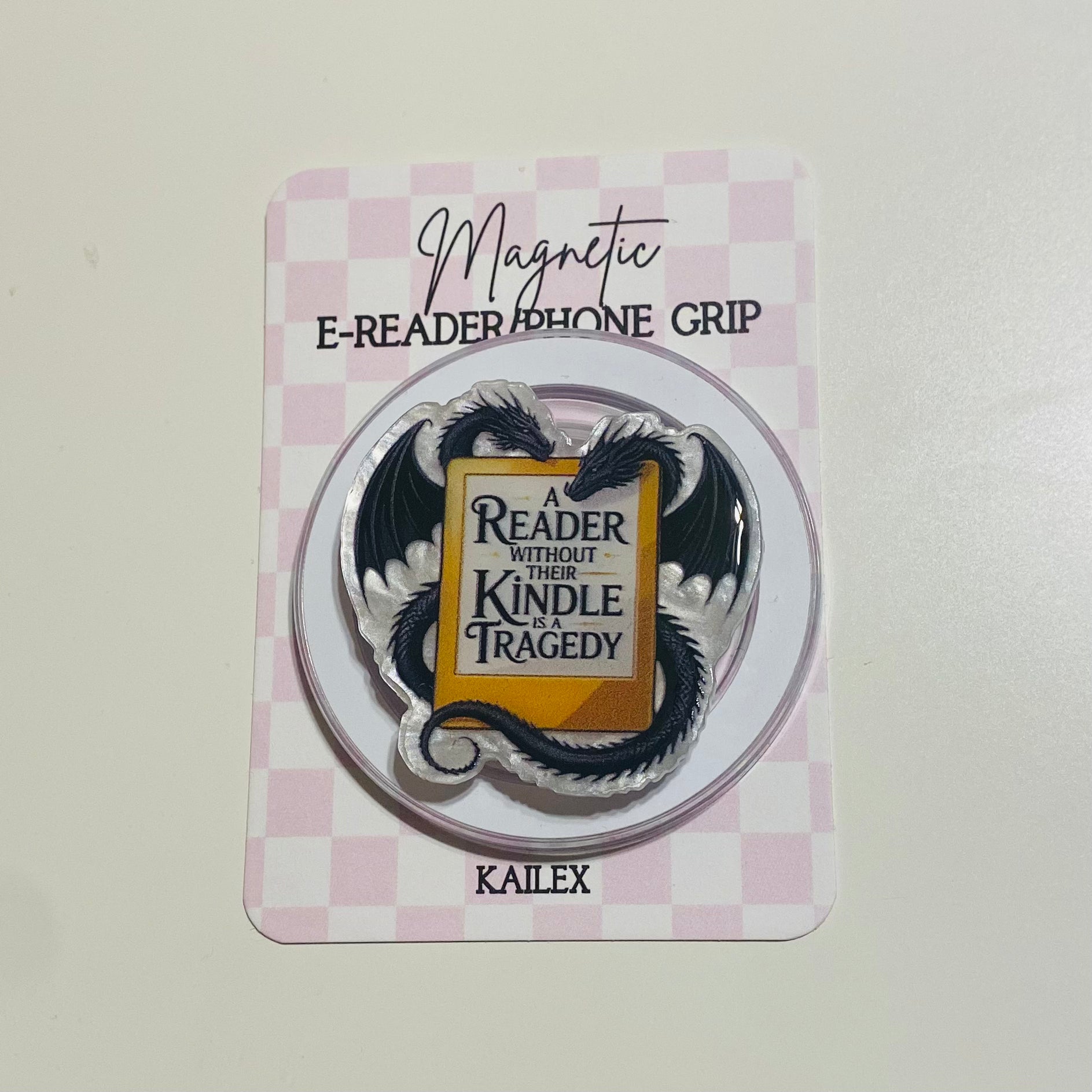 Magnetic e-reader phone grip with dragon design on a checkered card