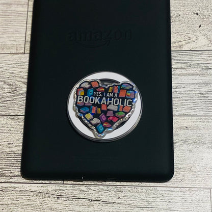 Heart-shaped magnetic e-reader phone grip with 'Bookaholic' text 