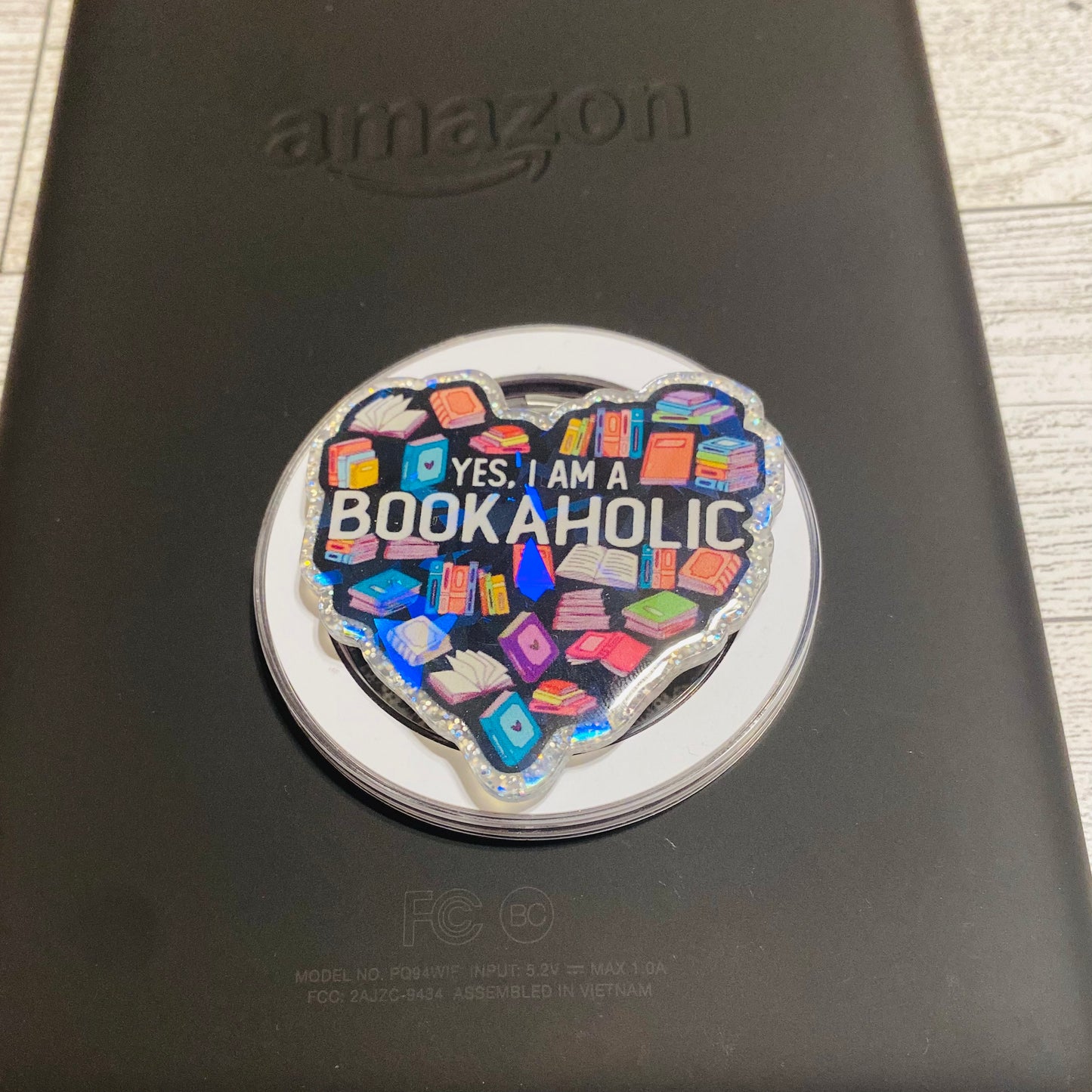 Heart-shaped magnetic e-reader phone grip with 'Bookaholic' text 