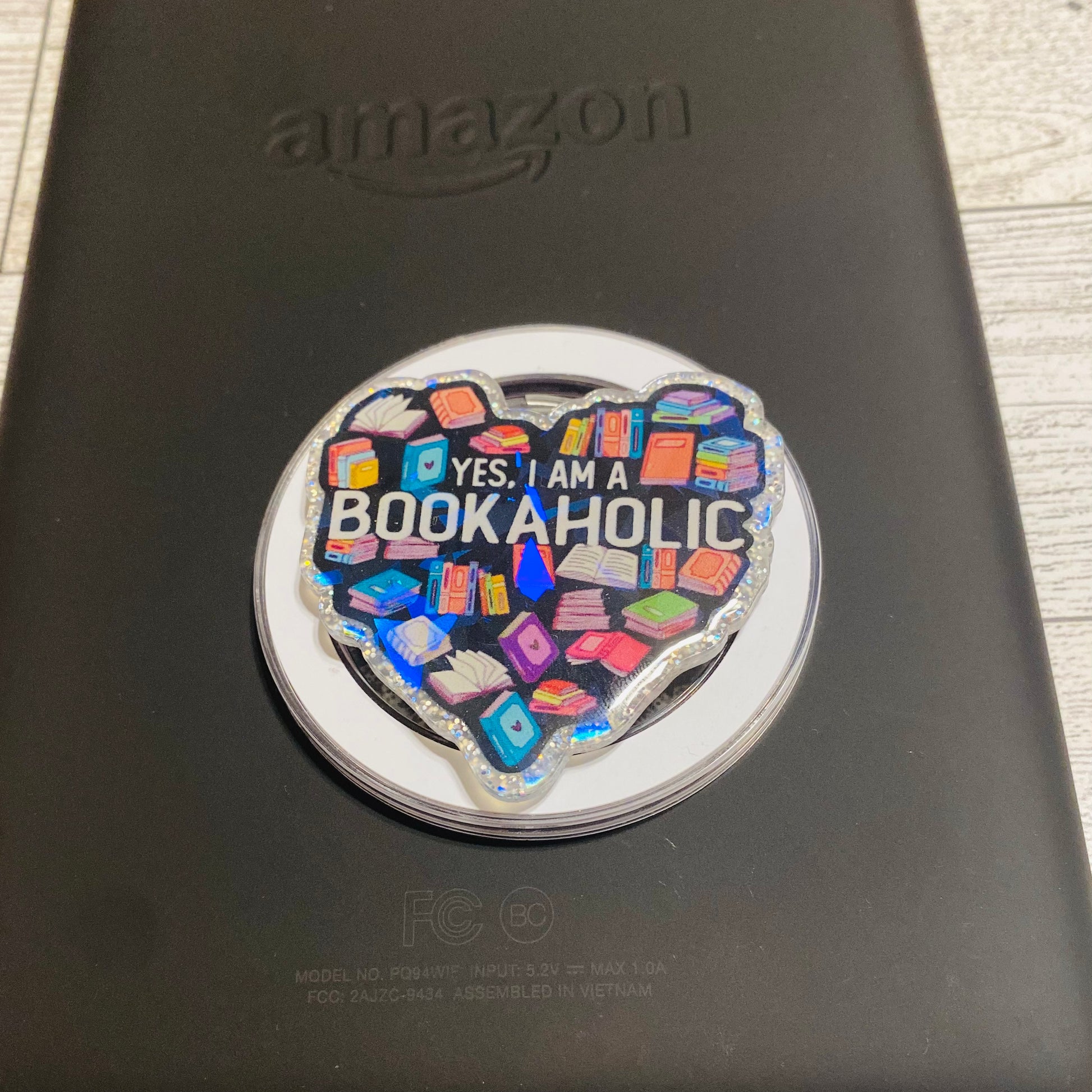 Heart-shaped magnetic e-reader phone grip with 'Bookaholic' text 