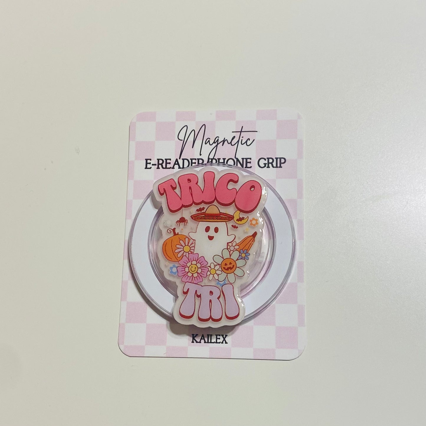 Magnetic e-reader phone grip with cartoon design on a checkered background