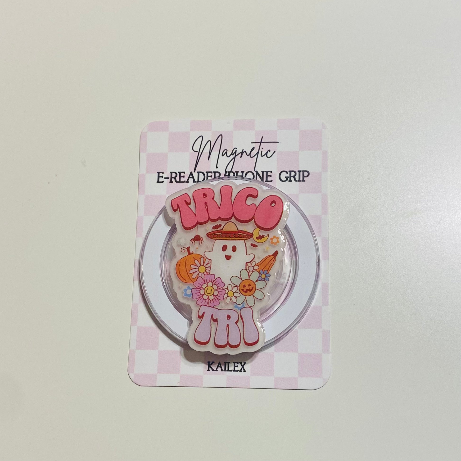 Magnetic e-reader phone grip with cartoon design on a checkered background