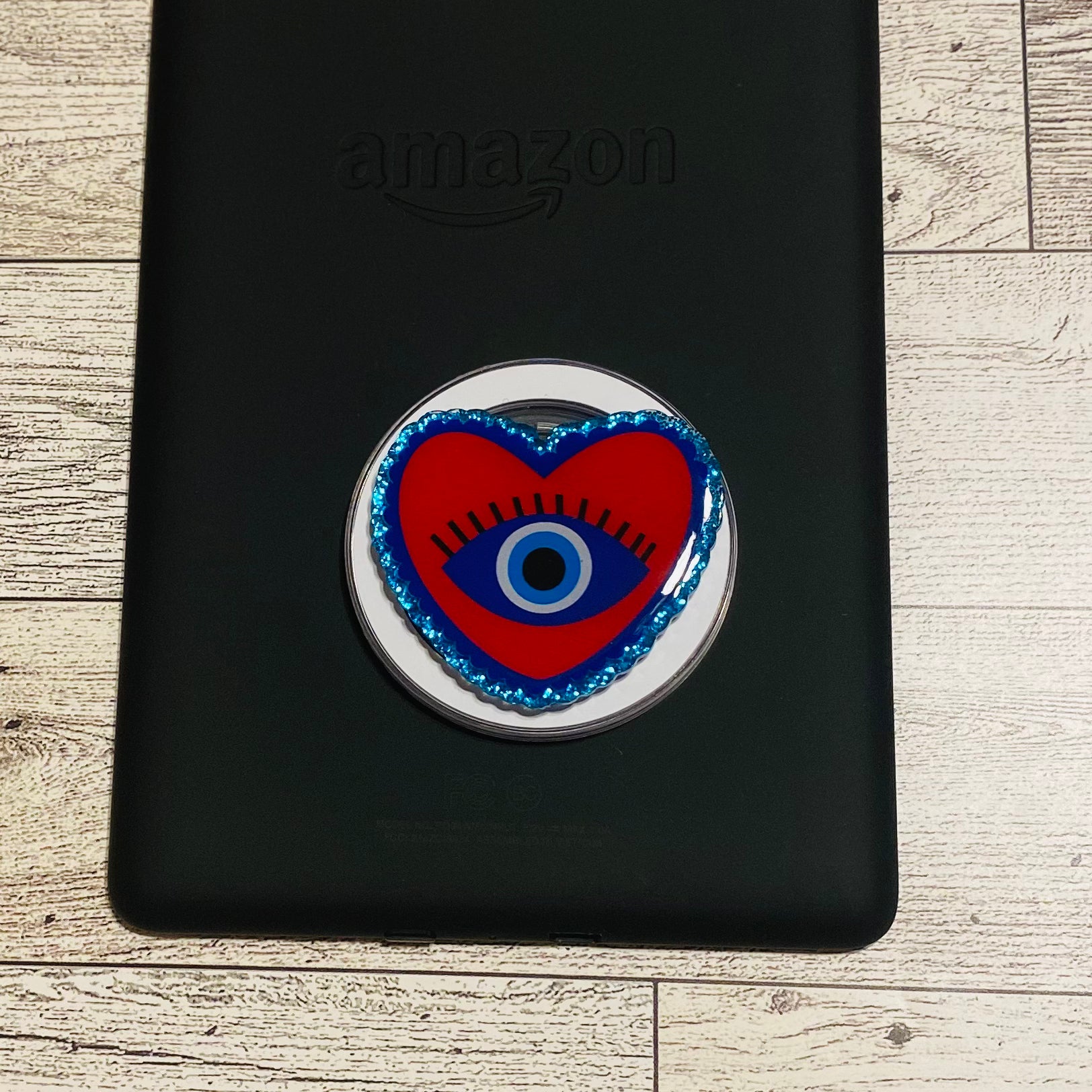 Heart-shaped e-reader phone grip with eye design 