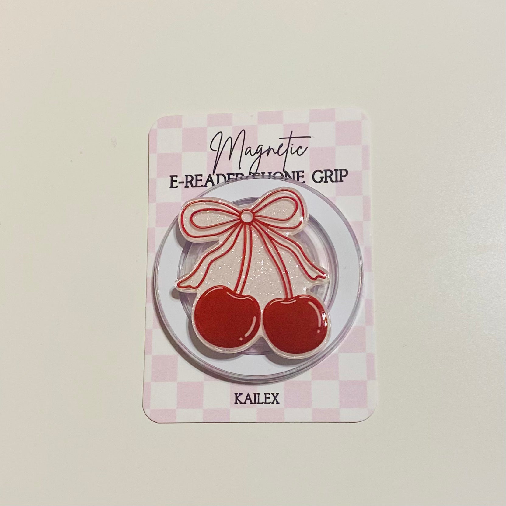 Magnetic e-reader phone grip with cherry design on a checkered background