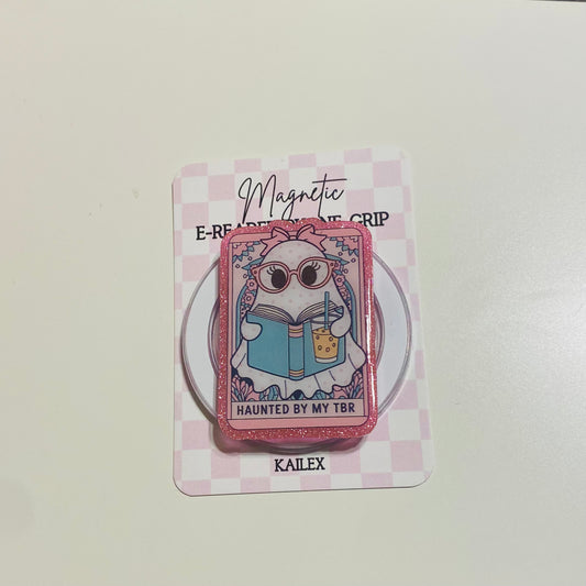 Magnetic e-reader book grip with cartoon character on a checkered card, brand 'KALEX' visible