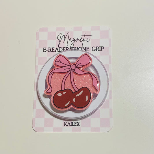 Magnetic e-reader phone grip with pink bow and cherries on a checkered card, brand 'KAILEX' visible