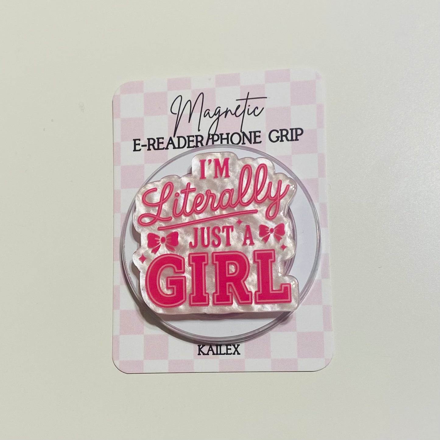 Magnetic e-reader/phone grip with 'I'm Literally Just a Girl' text on a checkered background