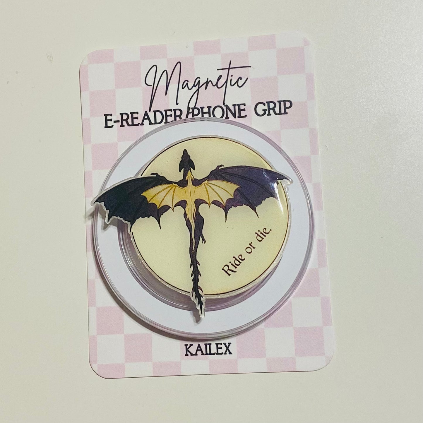 Magnetic e-reader phone grip with dragon design on a checkered background