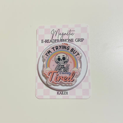 Magnetic e-reader phone grip with cartoon character and text on a checkered background