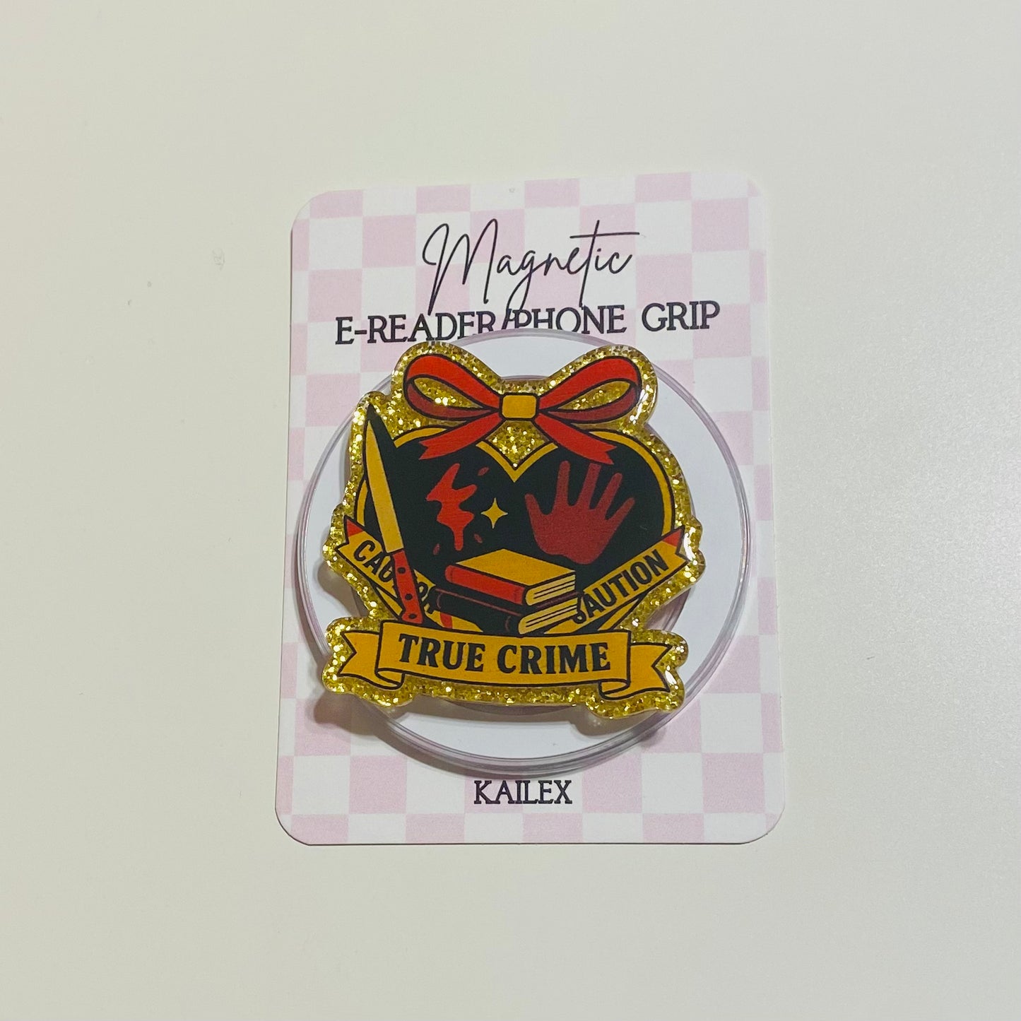true crime with yellow caution tape with red bow grip on checkered backing card
