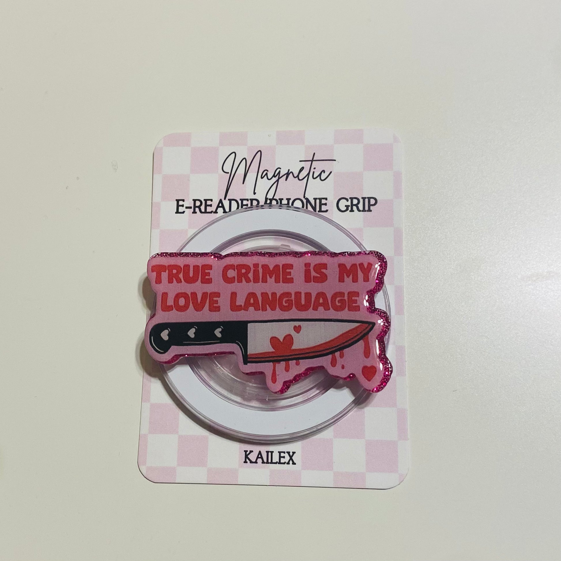 Magnetic e-reader phone grip with knife design and text on a checkered card