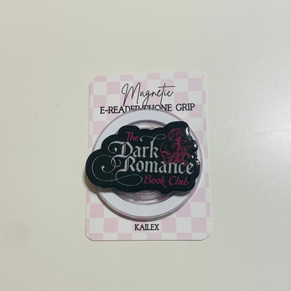 Magnetic e-reader phone grip with 'The Dark Romance Book Club' branding on a checkered background