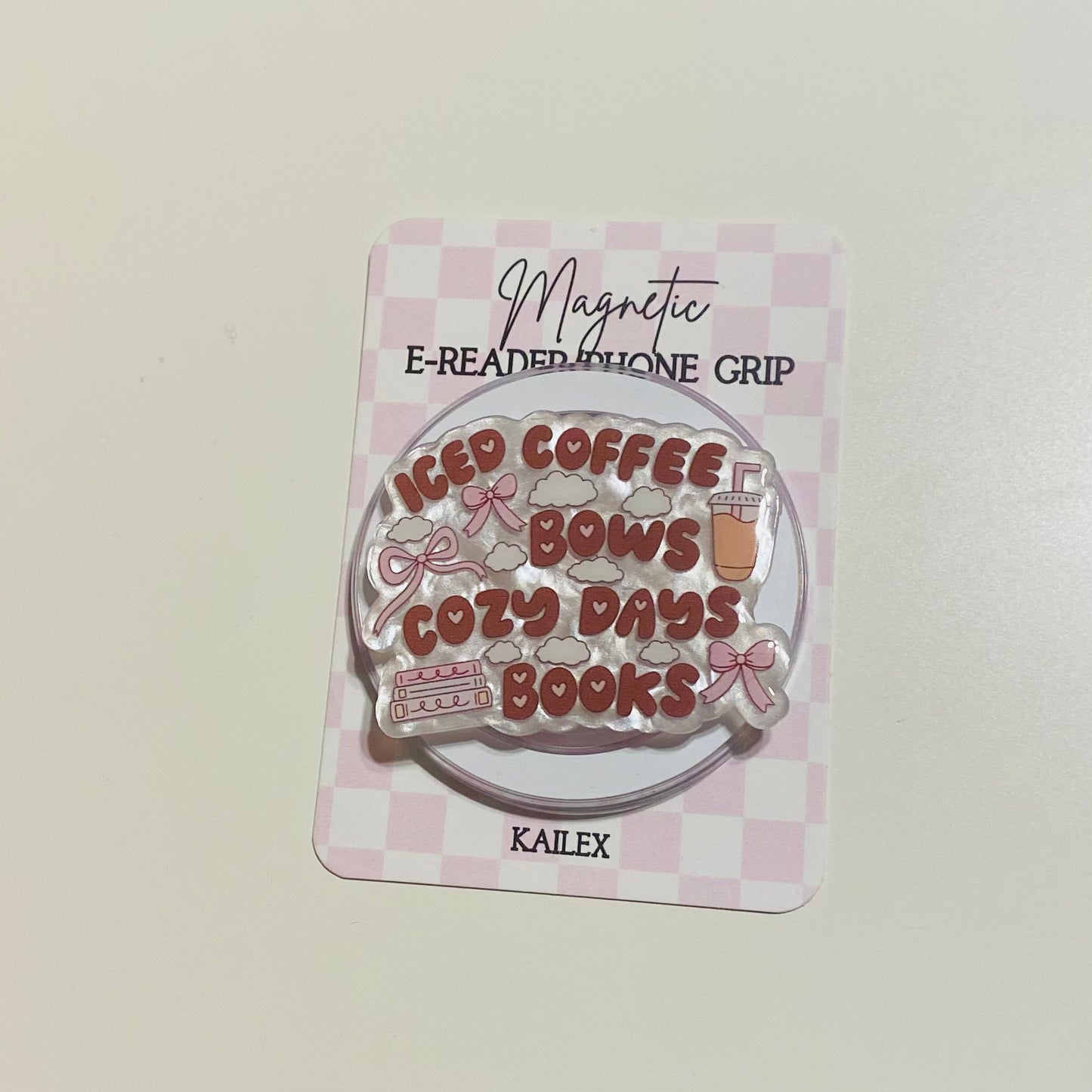 Magnetic e-reader phone grip with 'iced coffee, cozy days, books' text on a checkered background