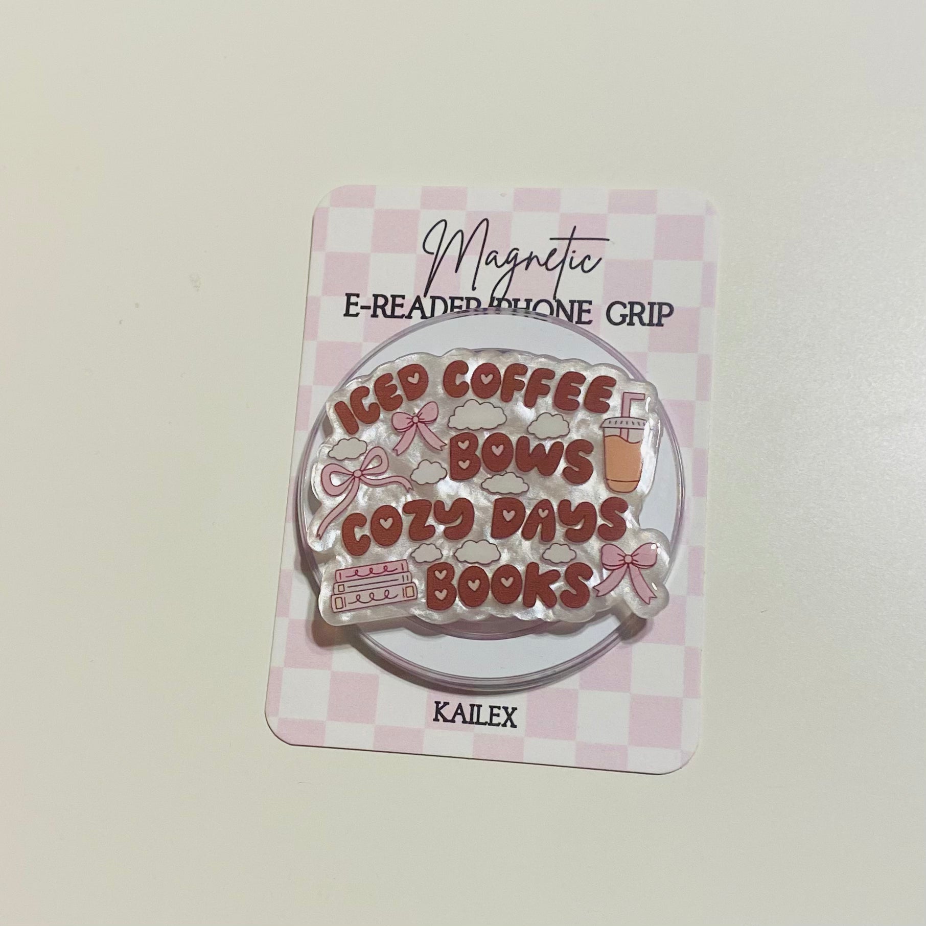 Magnetic e-reader phone grip with 'iced coffee, cozy days, books' text on a checkered background