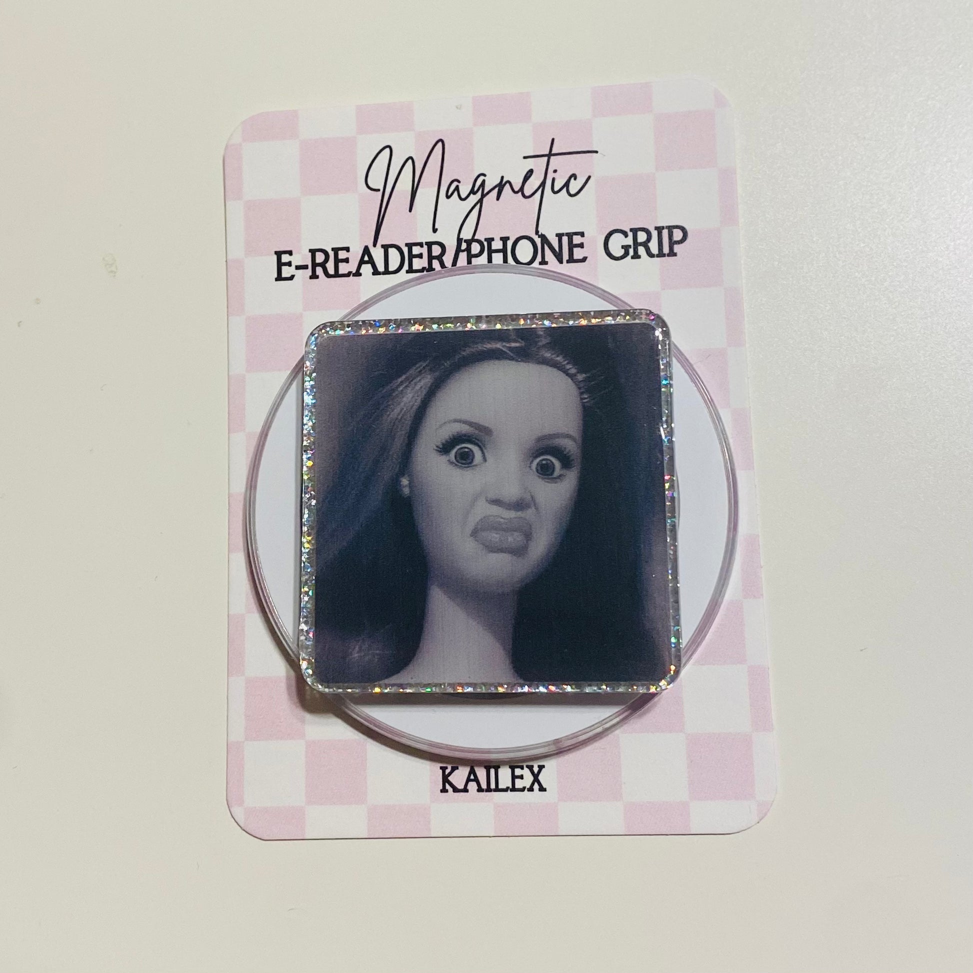 Magnetic e-reader phone grip with a face design on a checkered card, brand 'KAILEX' visible