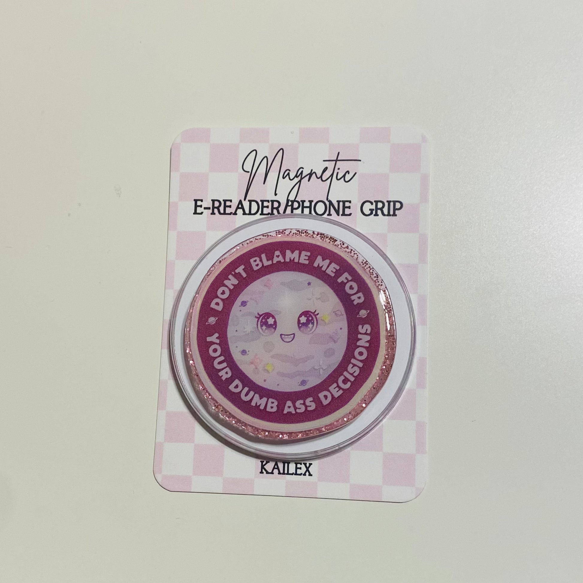 Magnetic e-reader phone grip on a checkered card with text