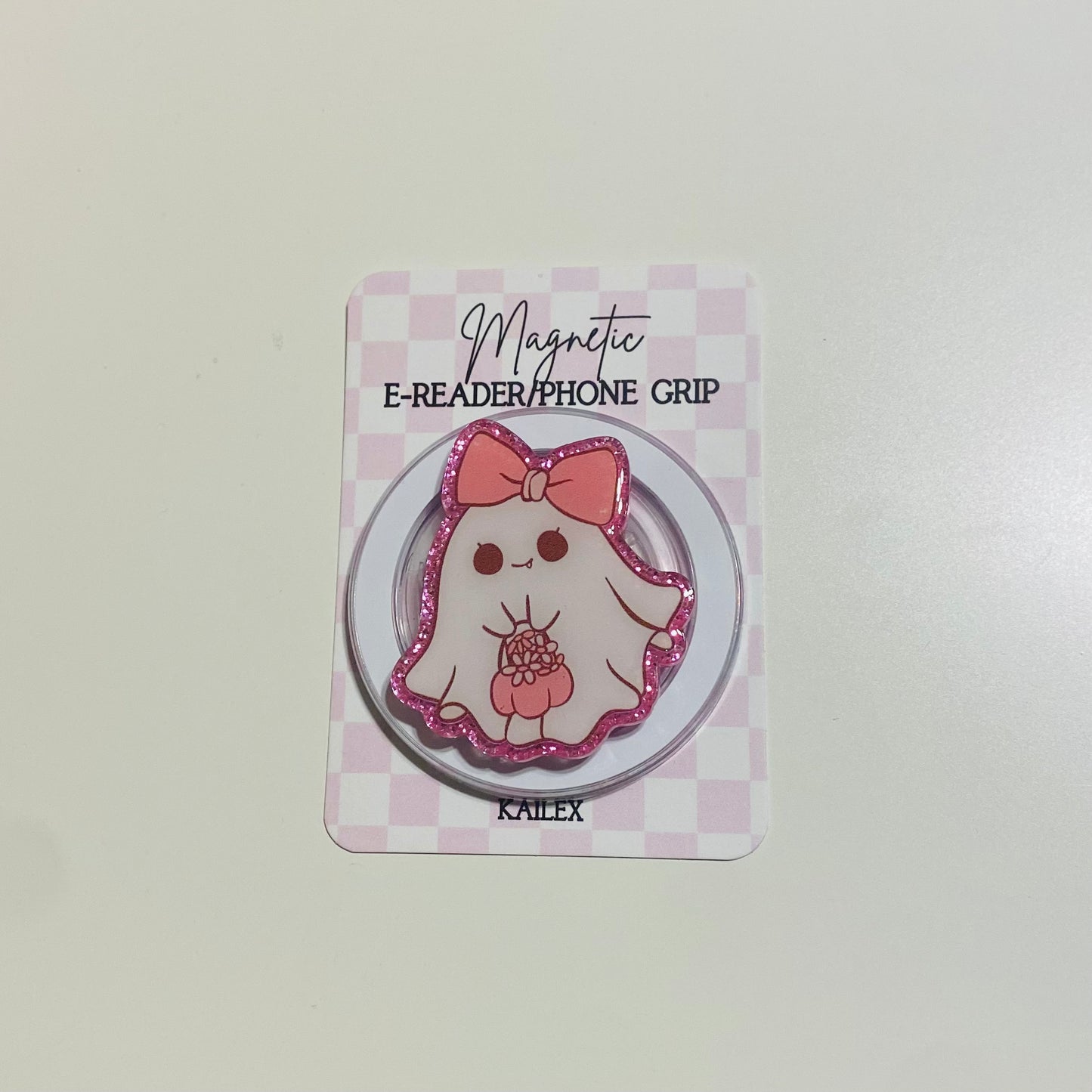 Magnetic e-reader/phone grip with cartoon character on a checkered card