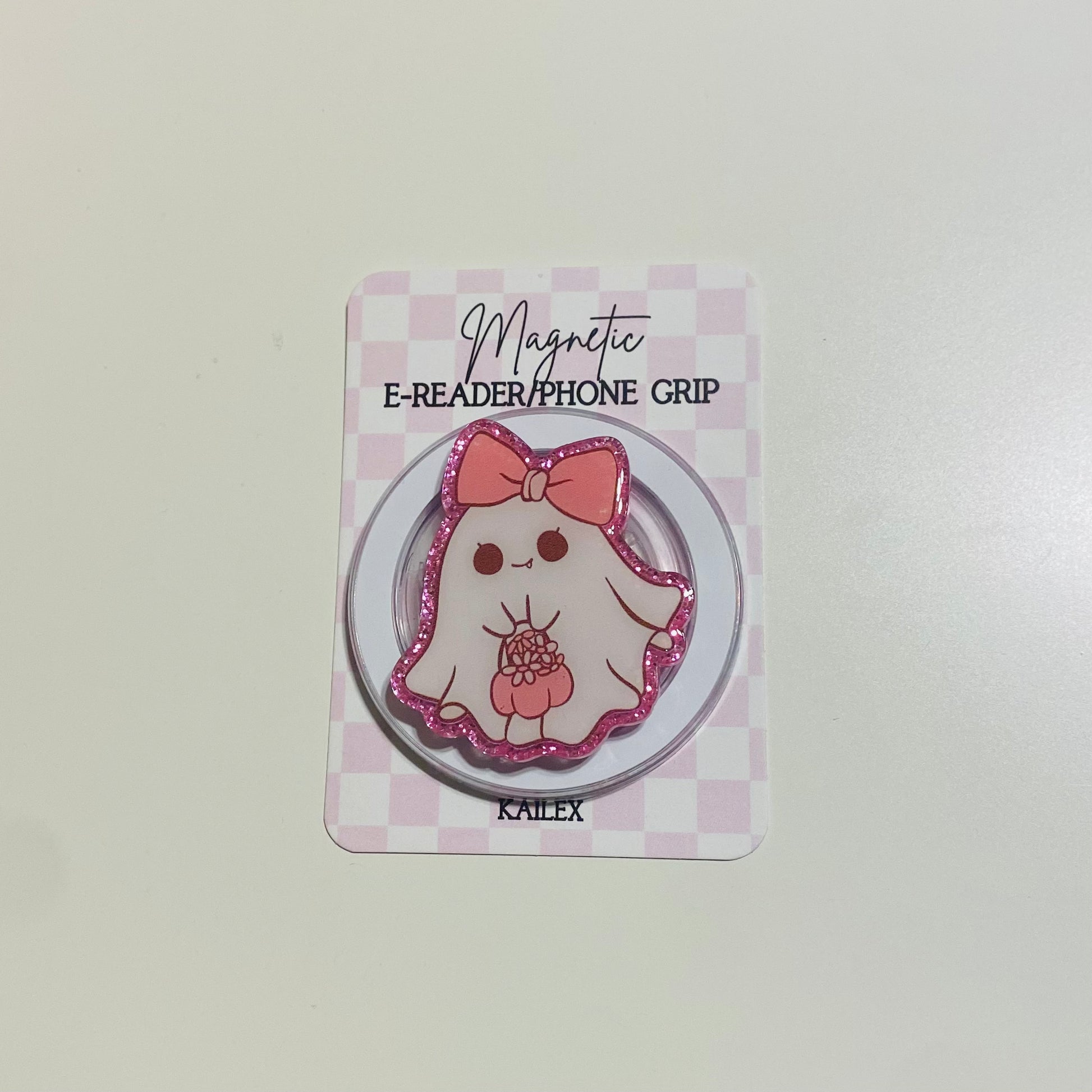 Magnetic e-reader/phone grip with cartoon character on a checkered card
