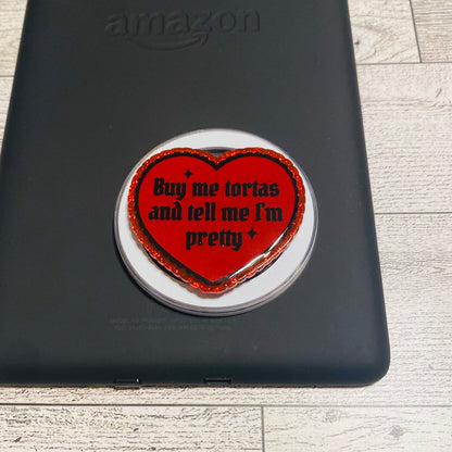 Red heart with text saying buy me tortas and tell me im pretty on black amazon device