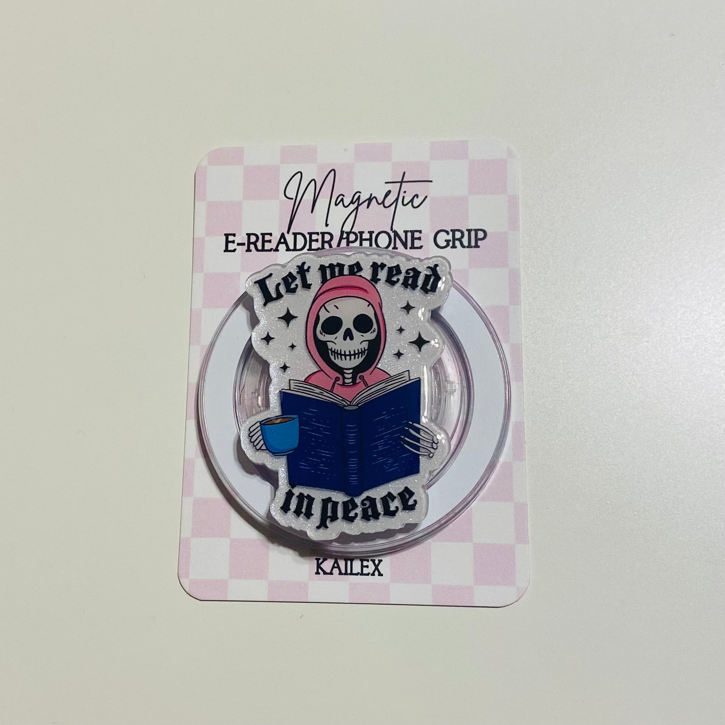 Magnetic e-reader phone grip with skeleton design on a checkered background