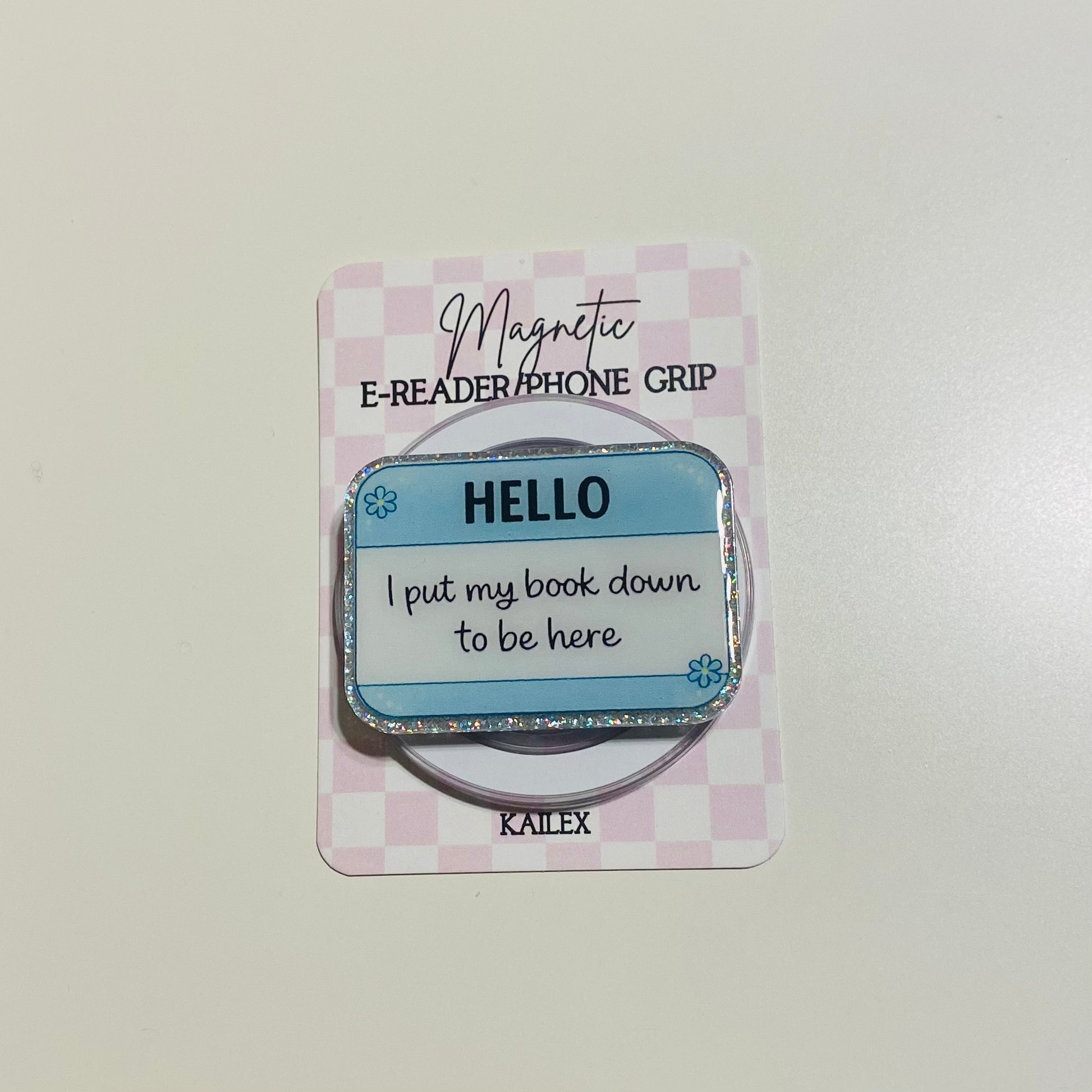 Magnetic e-reader phone grip with 'HELLO' text on a checkered card