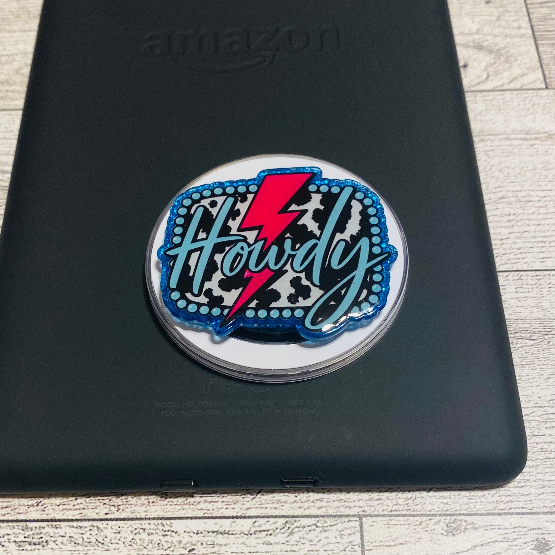 Magnetic e-reader phone grip with 'Howdy' design 