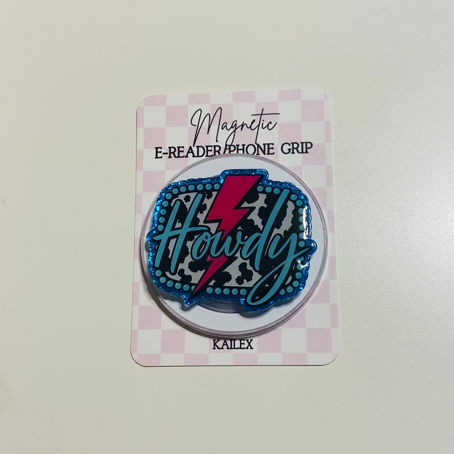Magnetic e-reader phone grip with 'Howdy' design on a checkered card