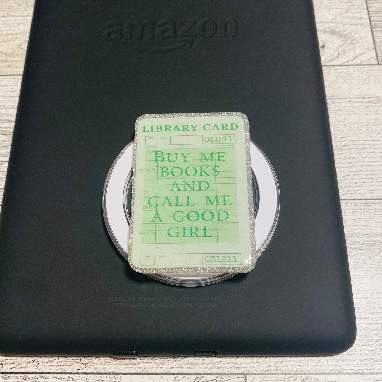Magnetic e-reader book grip with green 'library card' design 