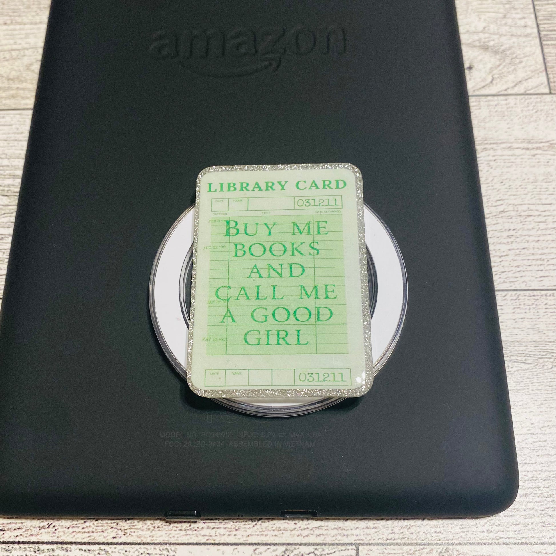 Magnetic e-reader book grip with green 'library card' design 