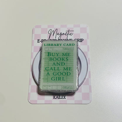 Magnetic e-reader book grip with green 'library card' design on a pink checkered background
