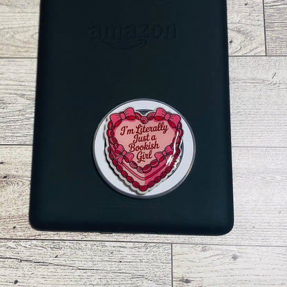 Heart-shaped magnetic e-reader phone grip with text on a checkered background