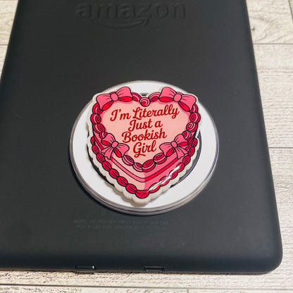 Heart-shaped magnetic e-reader phone grip with text on a checkered background