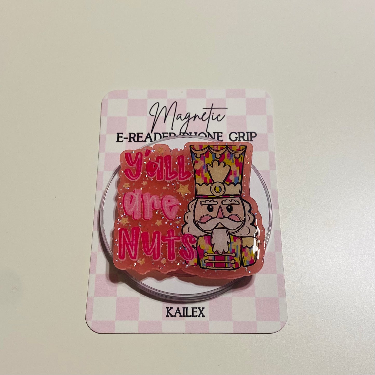Magnetic e-reader silicone grip with nutcracker design and text on a checkered card