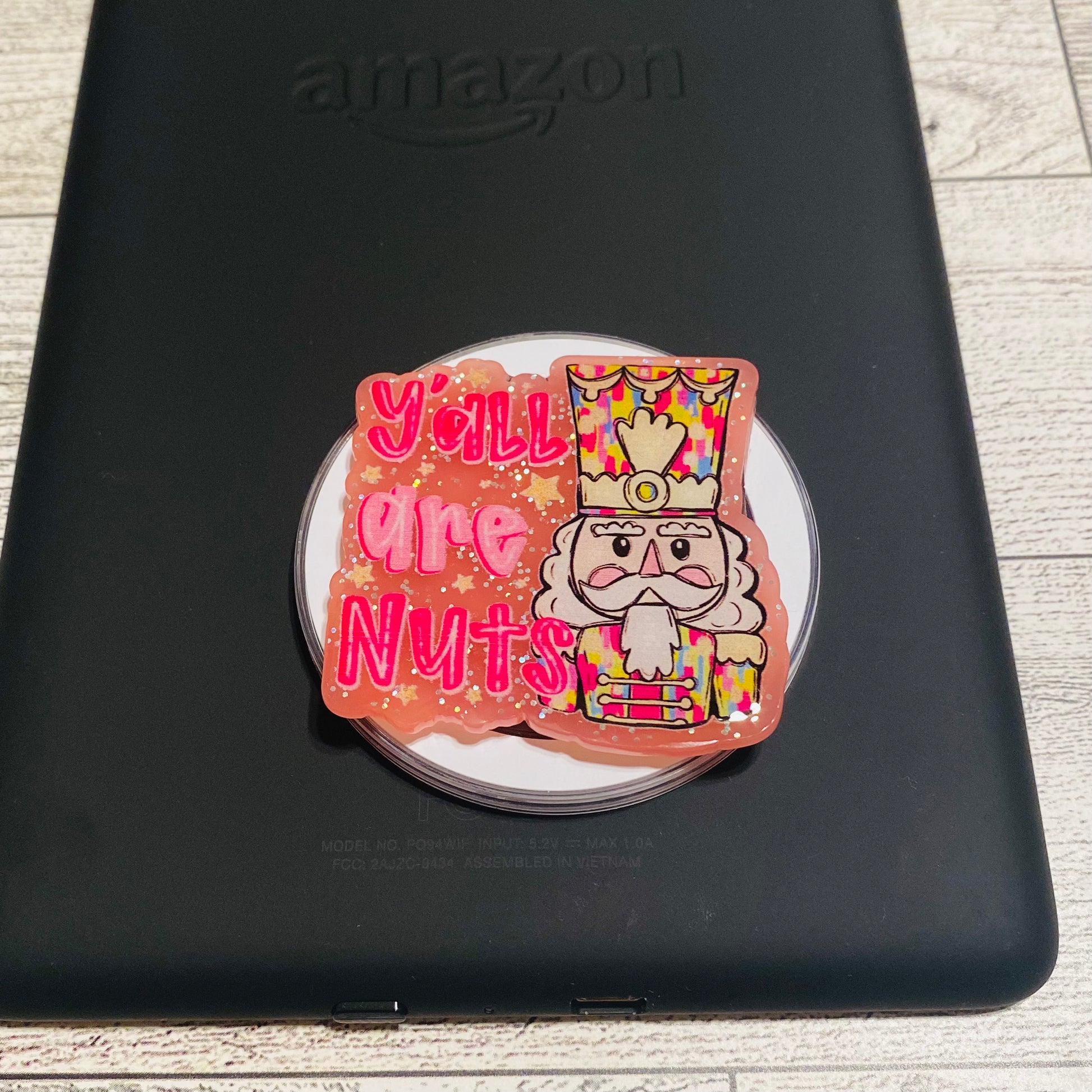 Magnetic e-reader silicone grip with nutcracker design and text on a checkered card