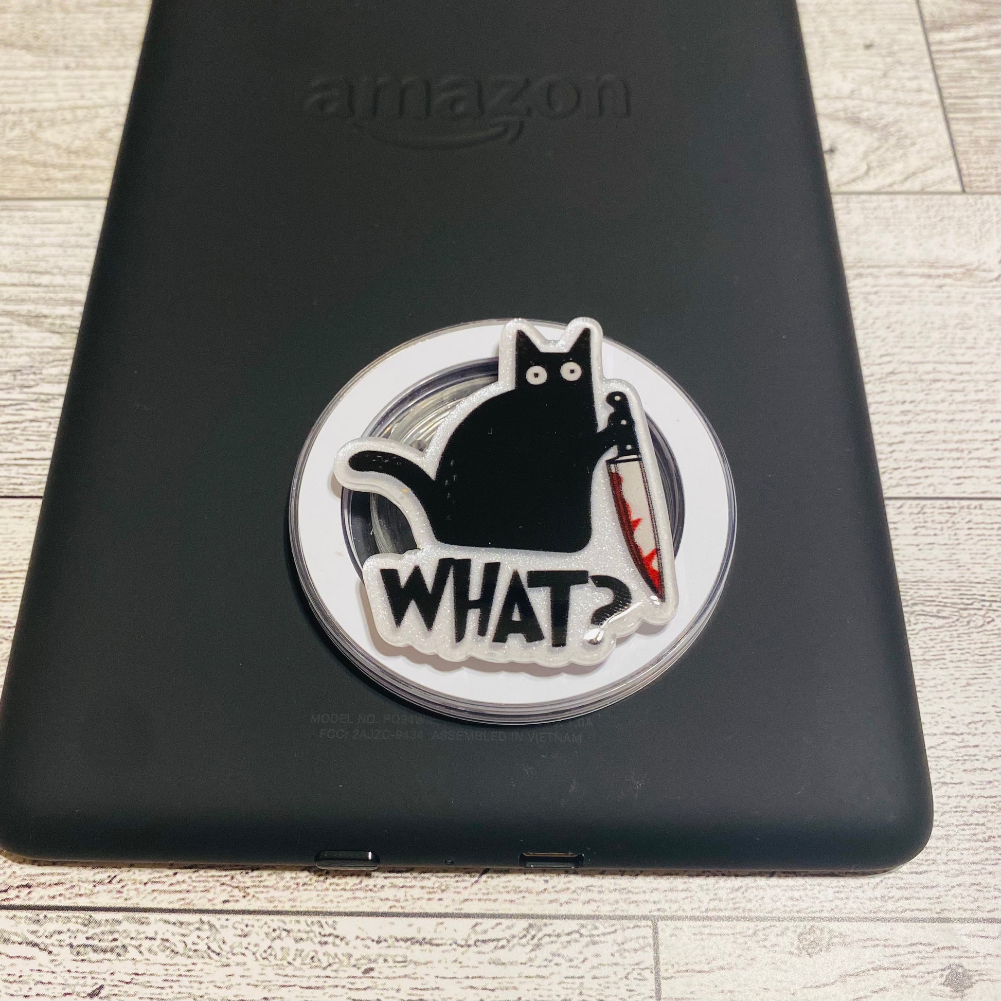 Magnetic e-reader phone grip with a black cat design on a checkered card